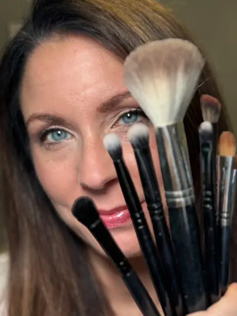 Kim Foerster with professional makeup brushes showcasing her makeup artistry skills